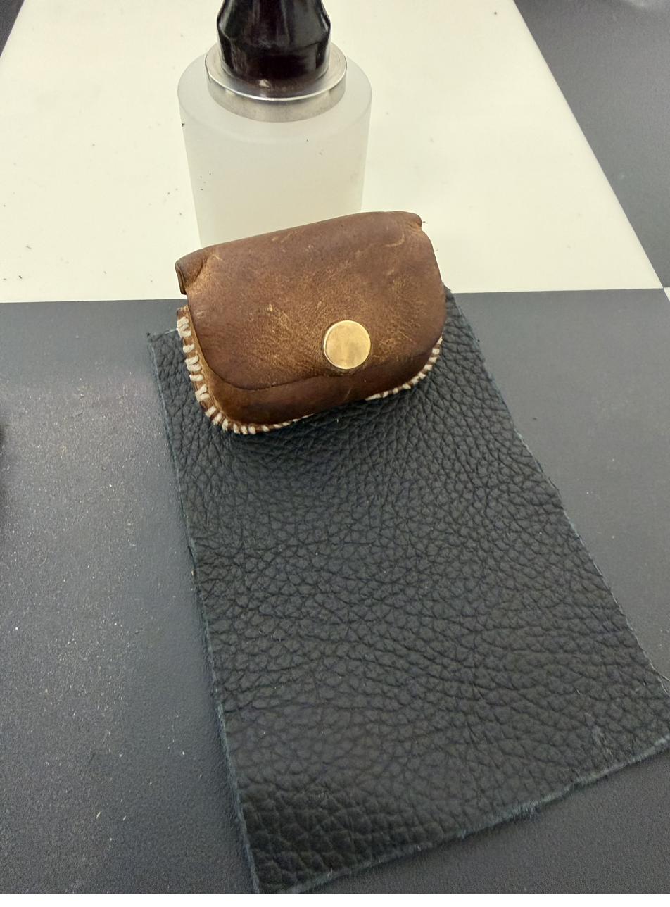Worn brown leather coin purse with brass snap