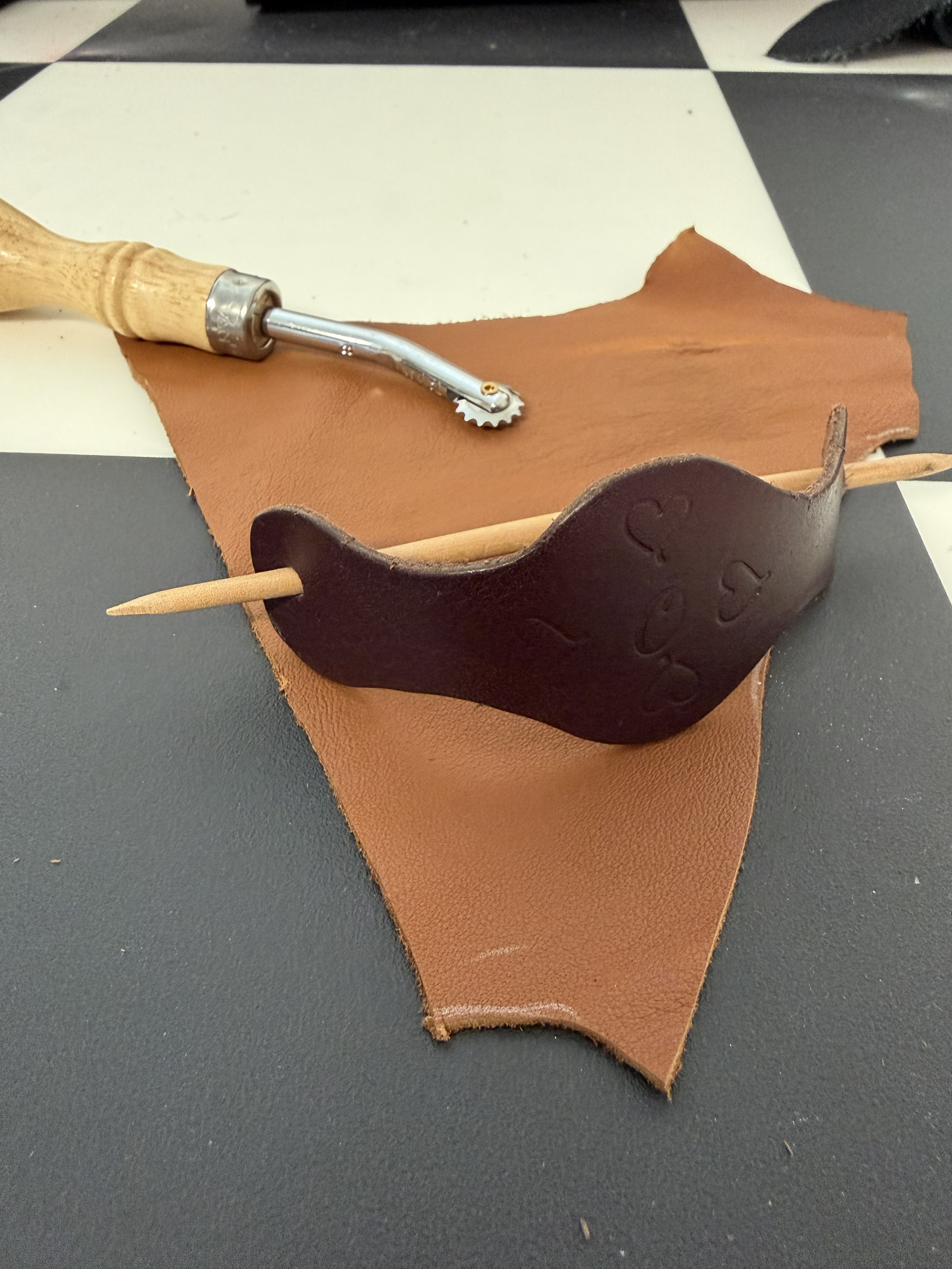 Curved leather bookmark with hand-stamped heart pattern