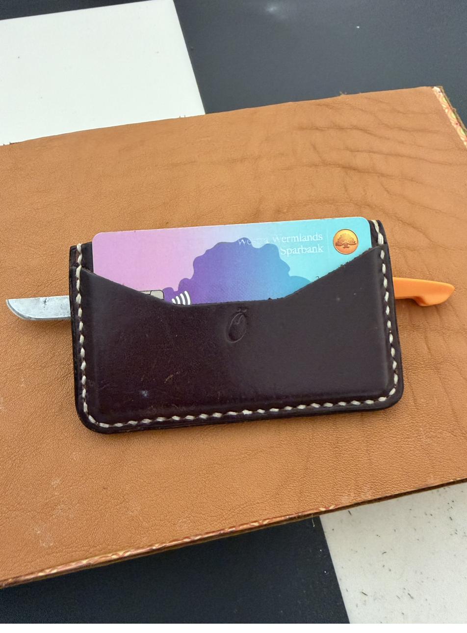 Slim card sleeve wallet with a bank card and pocket knife